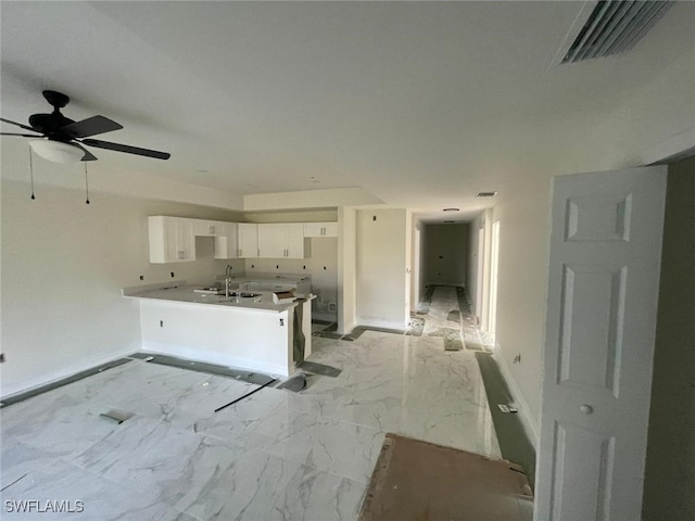 kitchen with kitchen peninsula, white cabinetry, ceiling fan, and sink