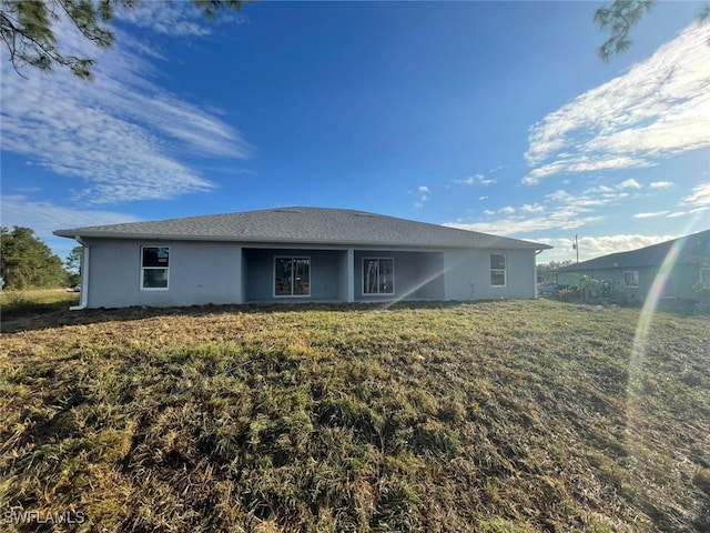 rear view of house featuring a lawn