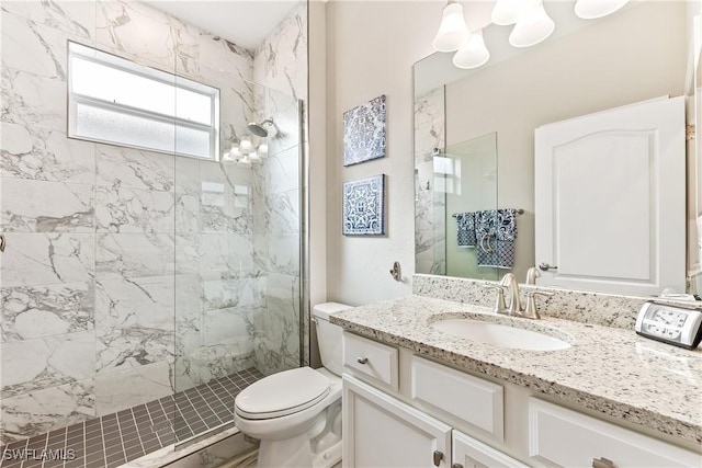 bathroom with toilet, vanity, and a tile shower