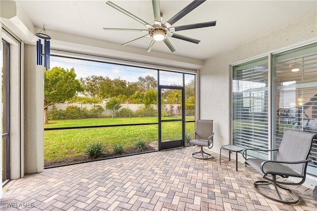 unfurnished sunroom with ceiling fan