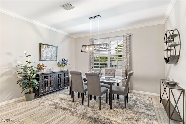 dining area with light wood-type flooring and crown molding