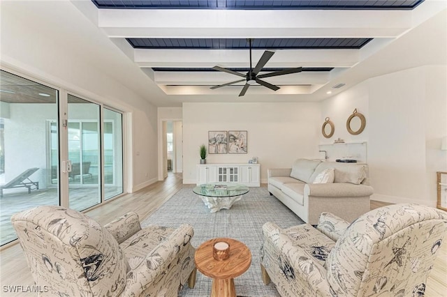 living room featuring beam ceiling, light hardwood / wood-style floors, and ceiling fan