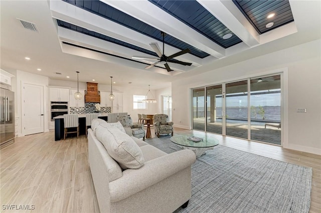 living room featuring beam ceiling, ceiling fan, and light hardwood / wood-style floors