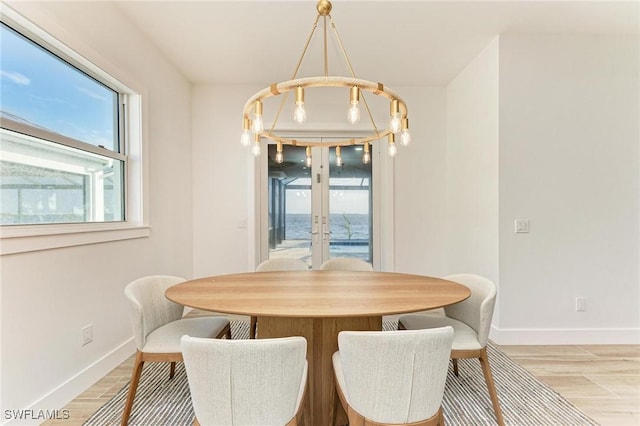 dining room with french doors and light hardwood / wood-style flooring