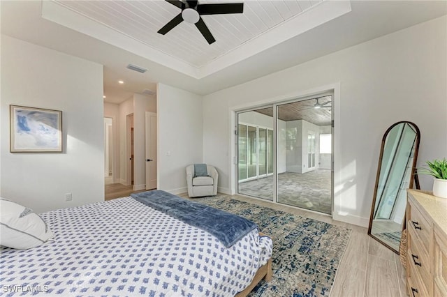 bedroom with access to exterior, ceiling fan, light hardwood / wood-style floors, a tray ceiling, and wood ceiling