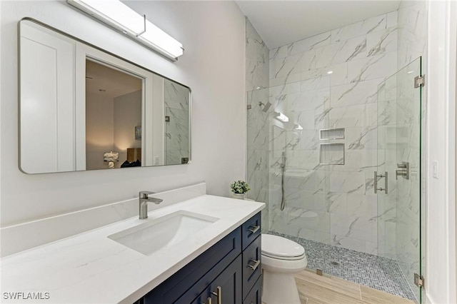 bathroom with an enclosed shower, vanity, toilet, and hardwood / wood-style floors