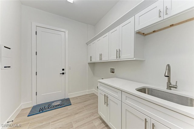 clothes washing area with washer hookup, cabinets, and sink