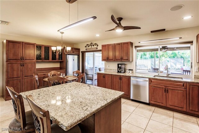 kitchen featuring sink, a wealth of natural light, a kitchen island, pendant lighting, and appliances with stainless steel finishes