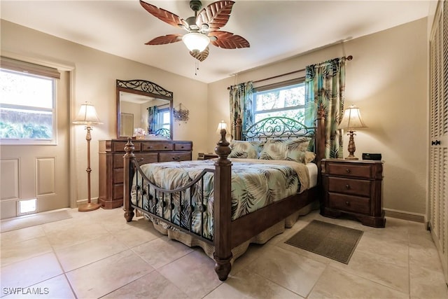 tiled bedroom with multiple windows and ceiling fan