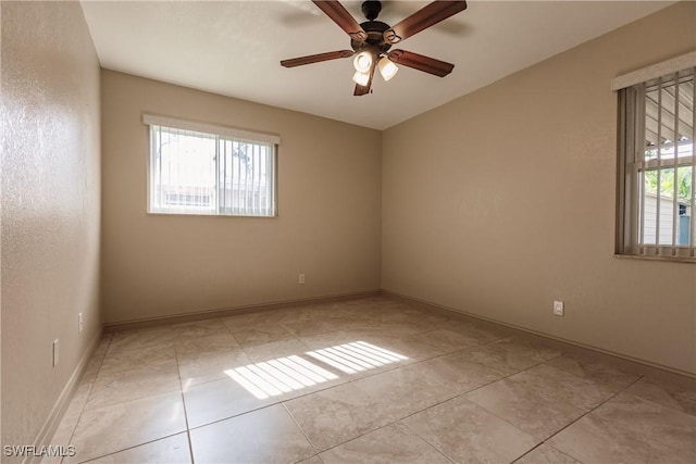 tiled spare room featuring ceiling fan