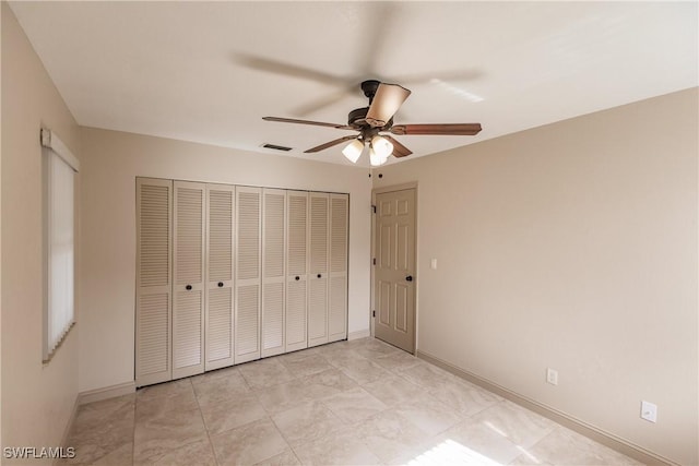 unfurnished bedroom with ceiling fan and a closet