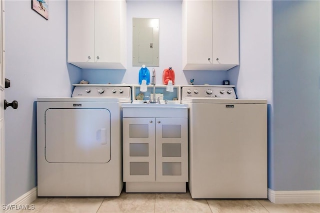 laundry room with electric panel, cabinets, light tile patterned floors, and washer and clothes dryer