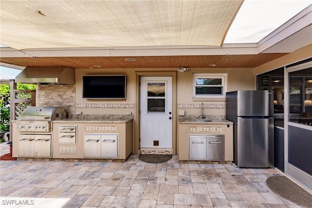 view of patio with exterior kitchen, sink, and a grill