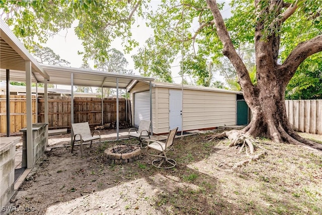 view of yard featuring an outdoor fire pit and an outbuilding