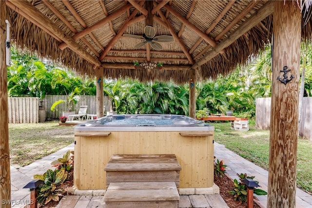 view of patio / terrace featuring ceiling fan, a hot tub, and a gazebo