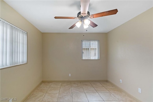 tiled empty room featuring ceiling fan