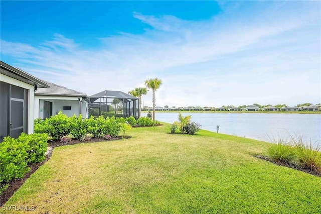 view of yard featuring a water view and glass enclosure