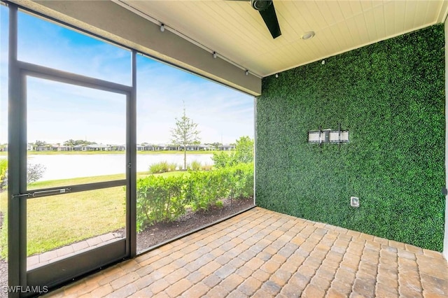 unfurnished sunroom with a water view and ceiling fan