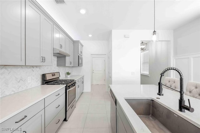 kitchen featuring sink, decorative light fixtures, gray cabinets, light tile patterned flooring, and appliances with stainless steel finishes