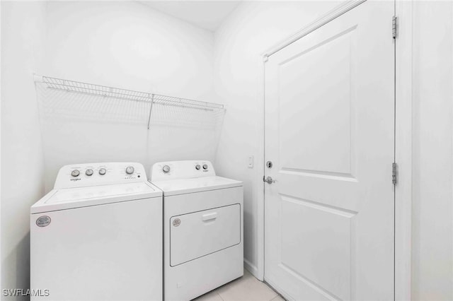 washroom with light tile patterned floors and washing machine and clothes dryer