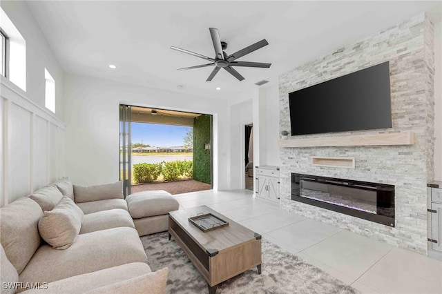 living room with ceiling fan, a fireplace, and light tile patterned floors