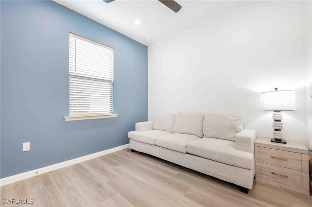 living room featuring ceiling fan and light hardwood / wood-style floors