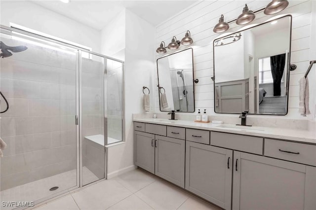 bathroom with a shower with door, vanity, and tile patterned flooring