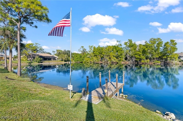 view of dock with a water view and a yard