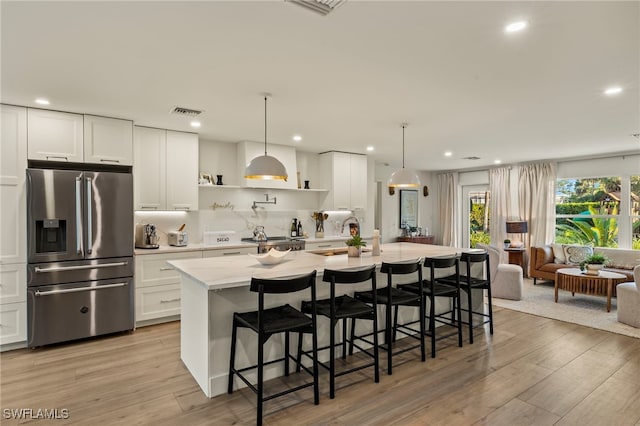 kitchen with white cabinetry, a center island with sink, and stainless steel appliances