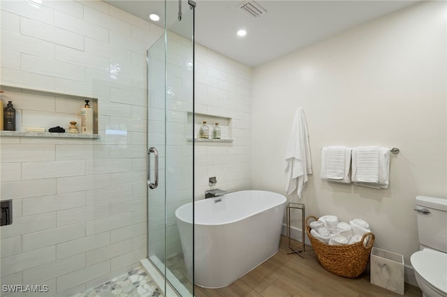 bathroom with hardwood / wood-style floors, toilet, and independent shower and bath