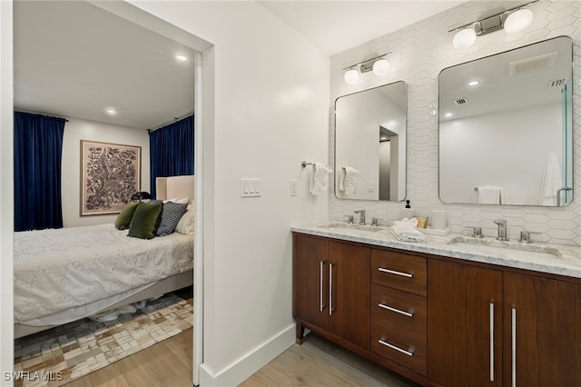 bathroom featuring hardwood / wood-style floors, decorative backsplash, and vanity