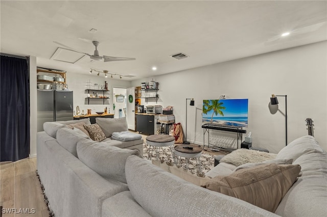 living room featuring light wood-type flooring and ceiling fan