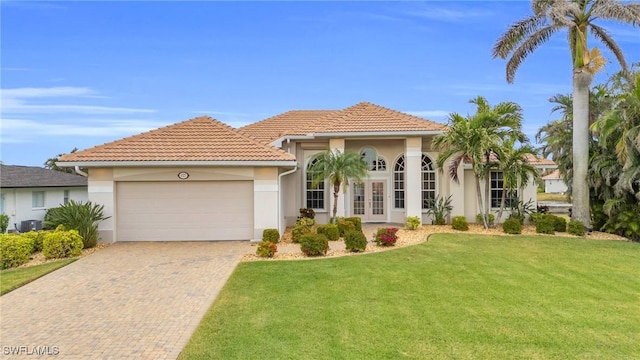 mediterranean / spanish house featuring a garage, a front yard, and french doors