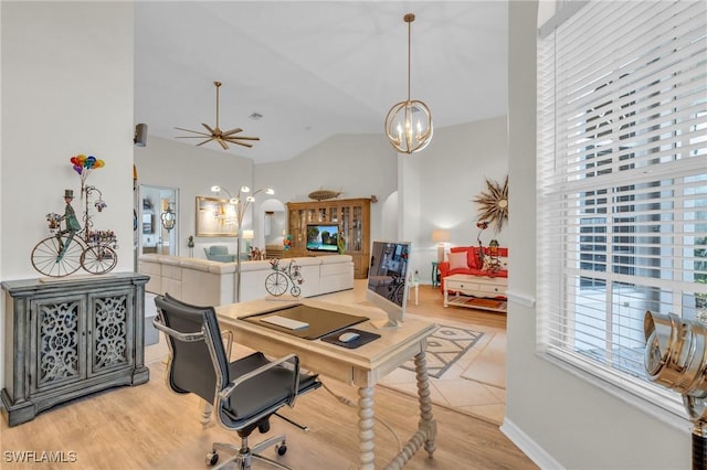 home office featuring light wood-type flooring, ceiling fan with notable chandelier, and high vaulted ceiling