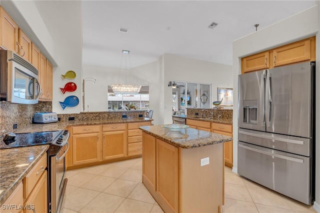 kitchen with kitchen peninsula, a center island, a notable chandelier, and appliances with stainless steel finishes