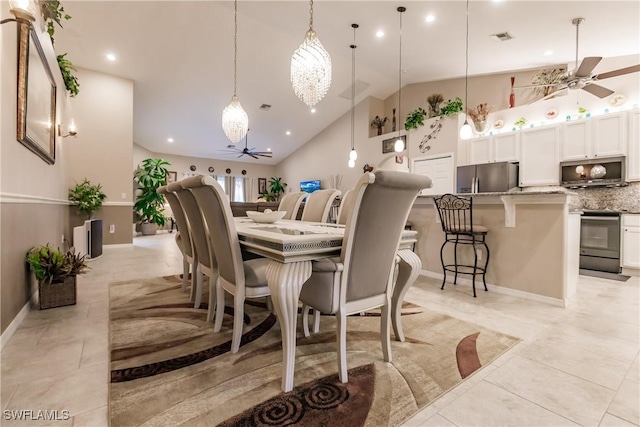 tiled dining space with high vaulted ceiling and ceiling fan with notable chandelier