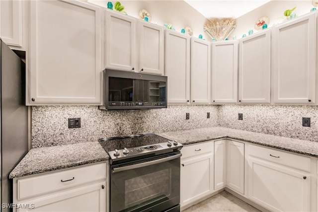 kitchen featuring white cabinets, appliances with stainless steel finishes, tasteful backsplash, and light stone counters