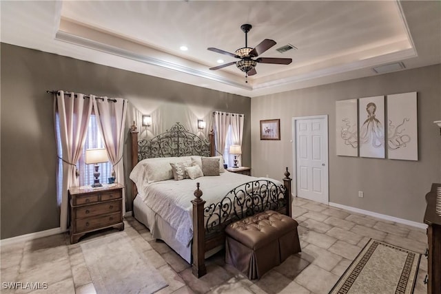 bedroom with ceiling fan and a raised ceiling