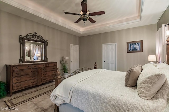 bedroom with a tray ceiling and ceiling fan