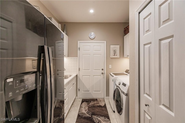 clothes washing area featuring light tile patterned flooring and separate washer and dryer