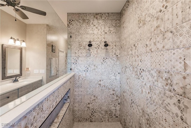 bathroom featuring ceiling fan, tiled shower, and vanity