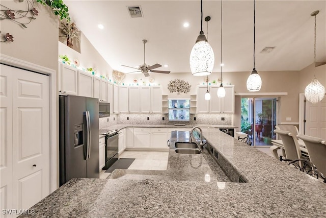 kitchen with black range with electric stovetop, stainless steel fridge, light stone countertops, decorative light fixtures, and white cabinetry