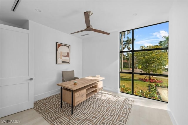 office featuring expansive windows, baseboards, a ceiling fan, and visible vents