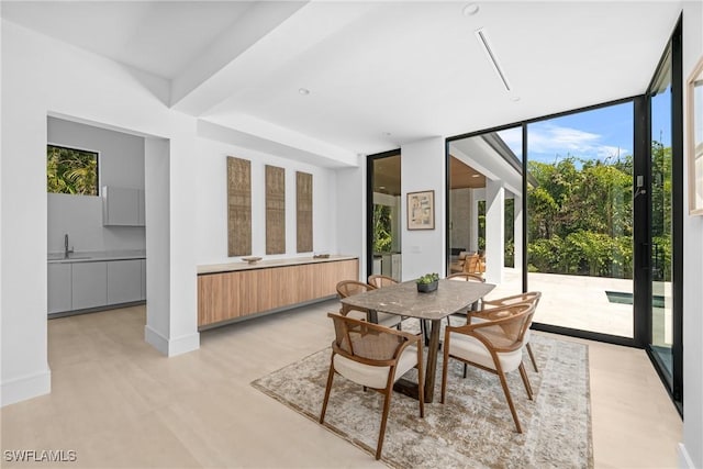 dining space featuring light wood-style flooring and a wall of windows
