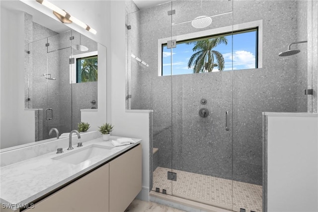full bath with a wealth of natural light, marble finish floor, and a shower stall