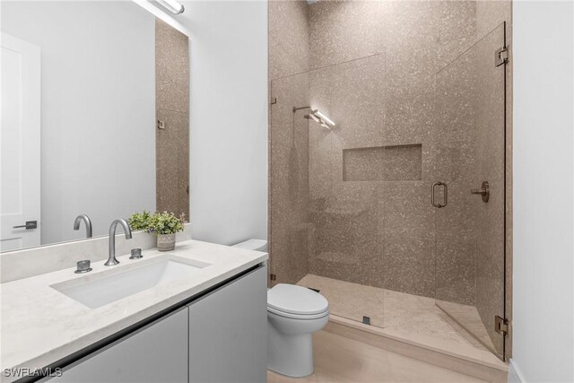 bathroom featuring a stall shower, vanity, and toilet