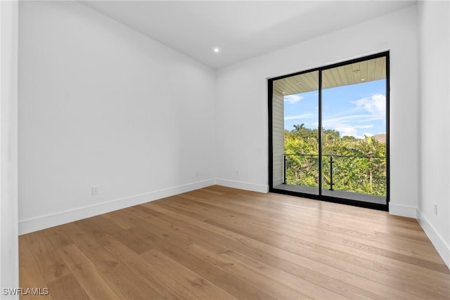 empty room with recessed lighting, baseboards, and light wood-style floors