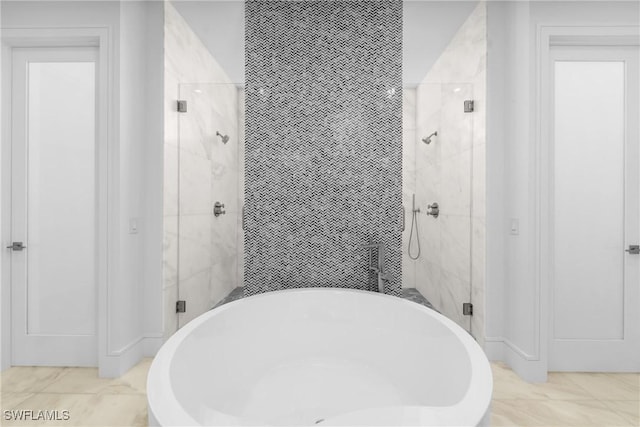bathroom with tile walls, a shower stall, and a freestanding tub