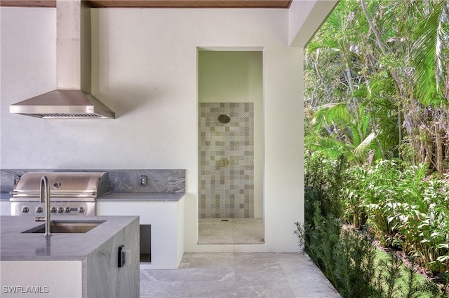 exterior space featuring wall chimney exhaust hood and a sink