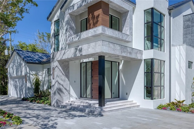 property entrance featuring a balcony and stucco siding